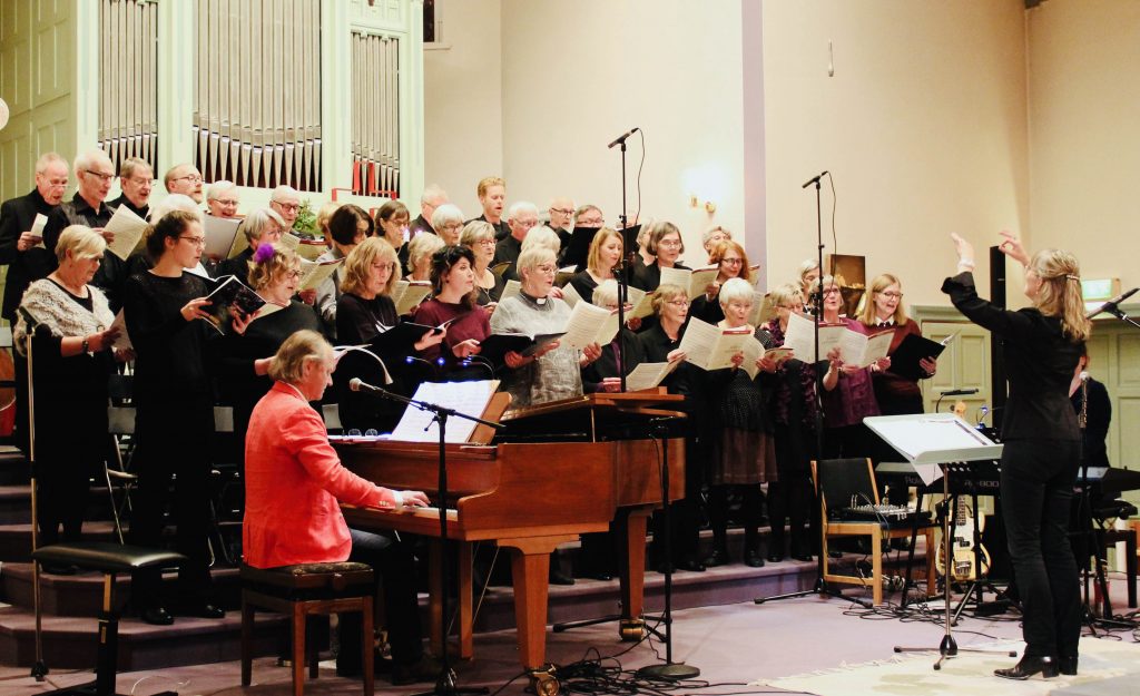 Kersti osm körpedagog dirigerar en kör under konsert